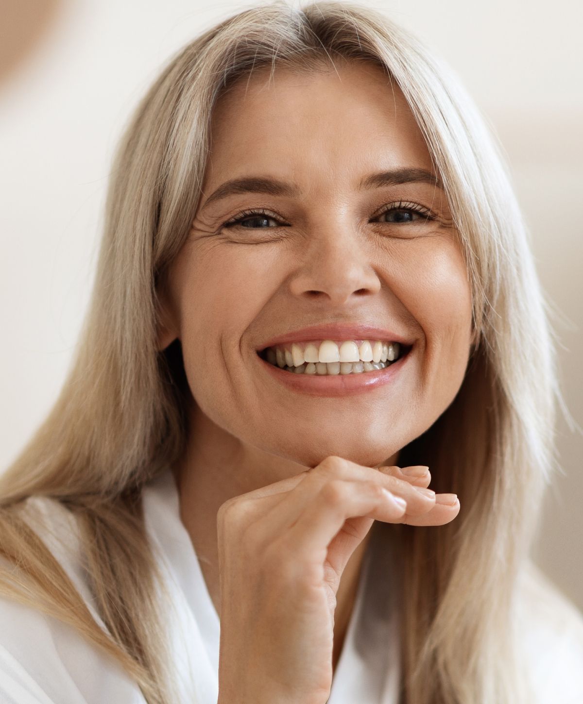 Smiling woman with blonde hair and joyful expression.