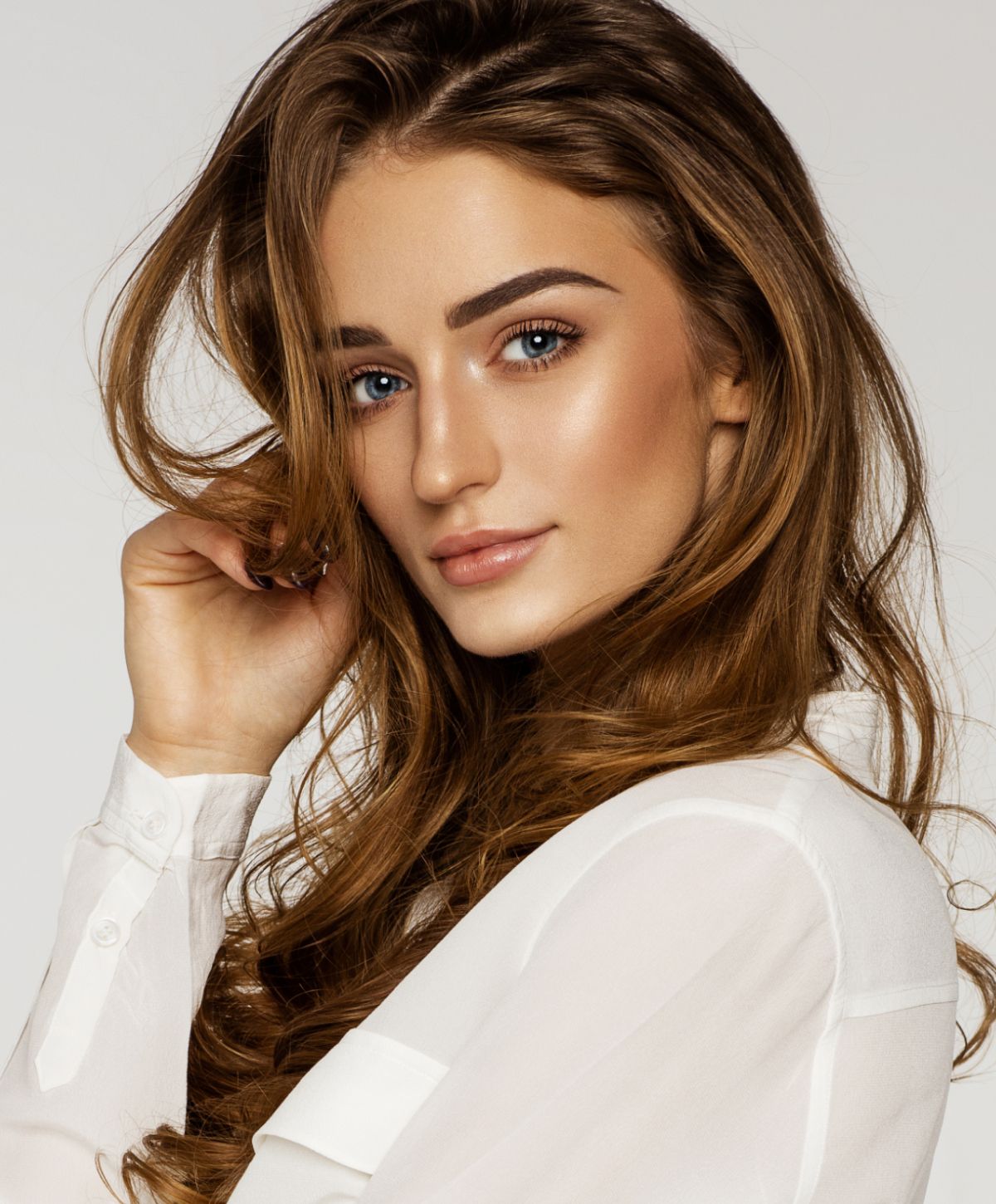 Portrait of an Orange County facial balancing model with long, wavy hair.