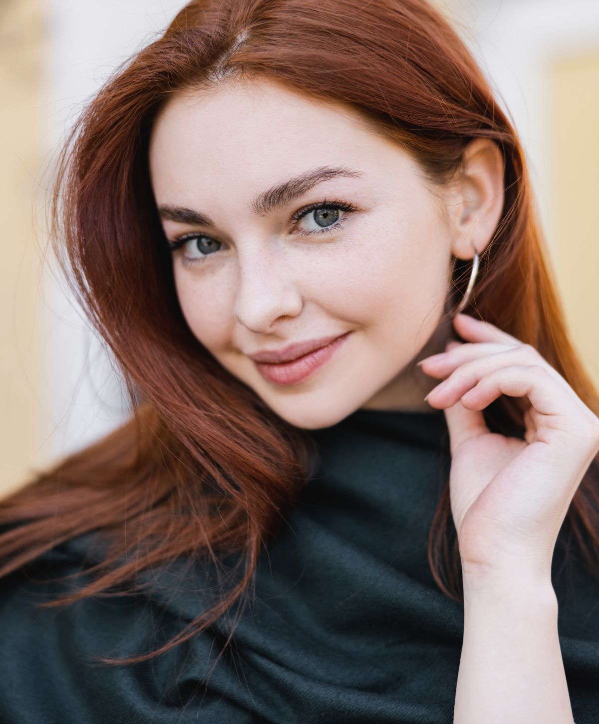 Orange County BBL laser model with red hair and hoop earrings.