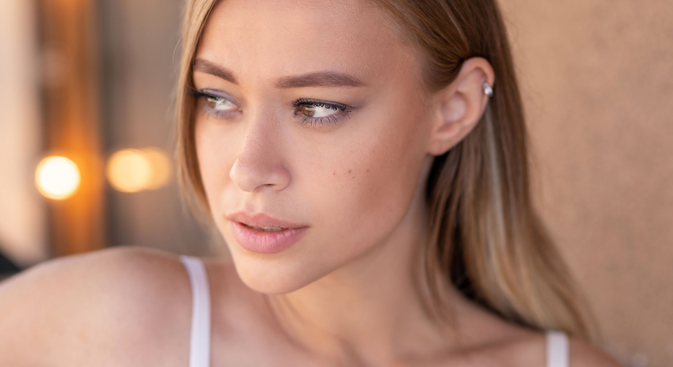 Mission Viejo acne treatments model with long hair looking thoughtfully to the side.